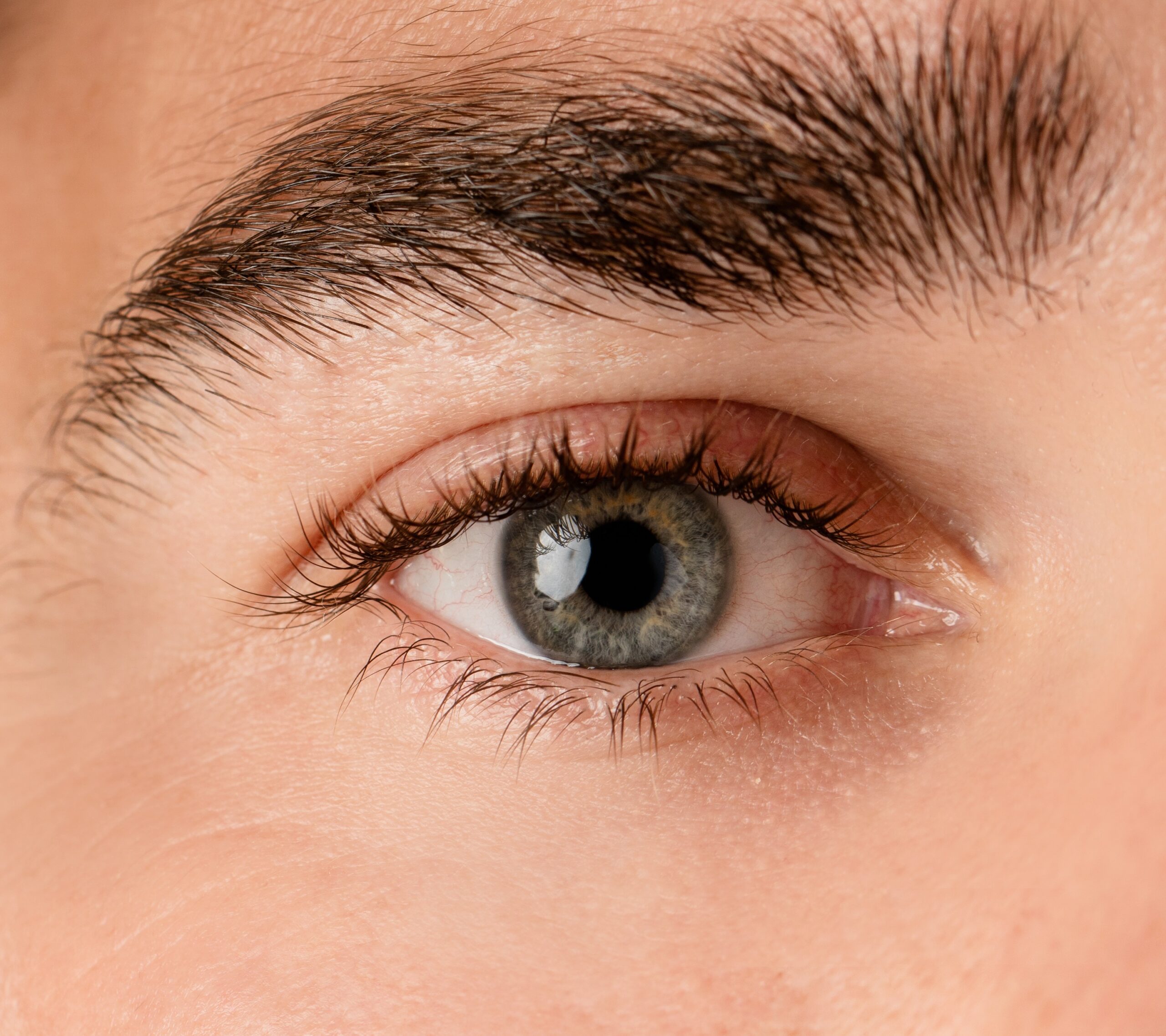 Close-up van mannelijk oog en pipet met een hydraterende olie